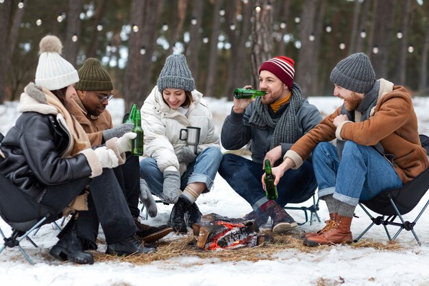 Amici felici a tutto campo con bottiglie di birra