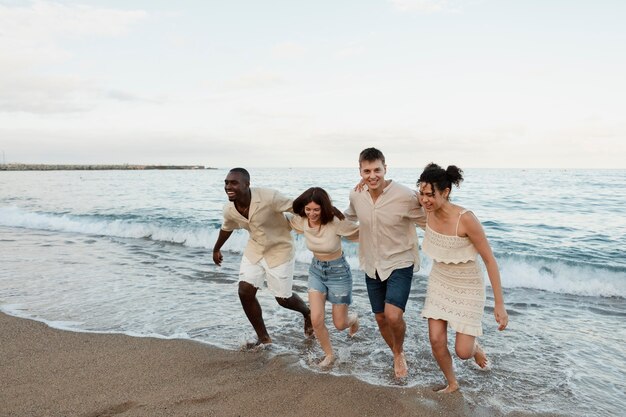 Amici felici a tutto campo in spiaggia