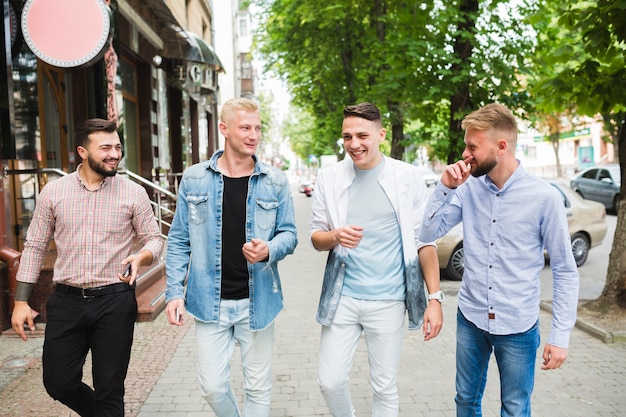 Amici felici che camminano insieme sul marciapiede