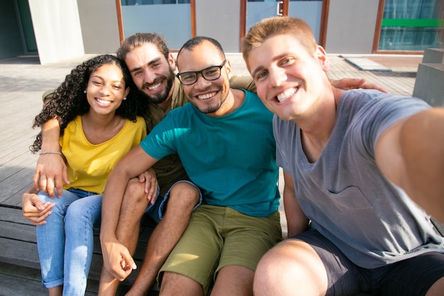 Amici felici che prendono selfie all'aperto