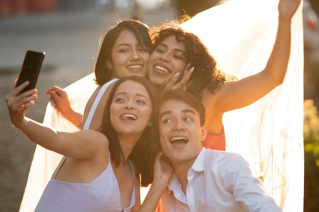 Amici felici del colpo medio che prendono selfie