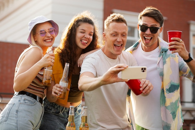 Amici felici del colpo medio che prendono selfie