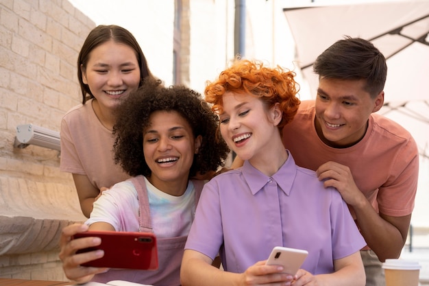 Amici felici del tiro medio che prendono selfie