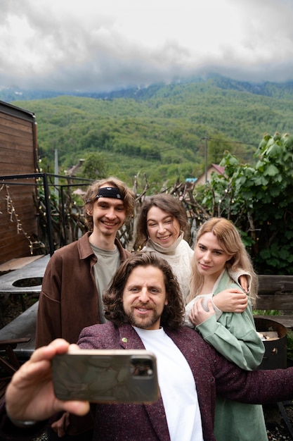 Amici felici dell'angolo alto che prendono selfie