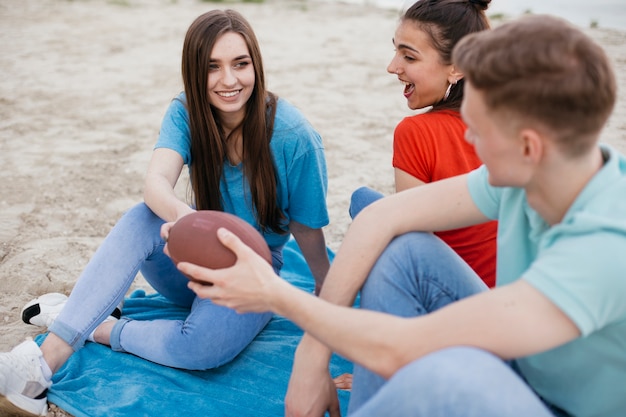 Amici felici dell'angolo alto con la palla di calcio