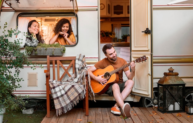 Amici felici in un furgone a suonare la chitarra