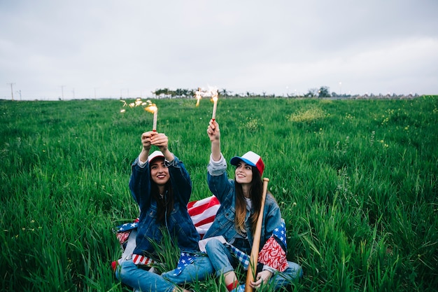 Amici femminili che celebrano la festa dell&#39;indipendenza su erba verde