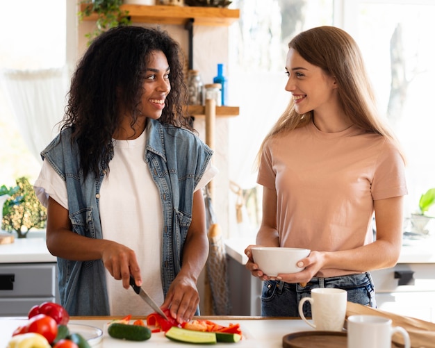 Amici femminili che cucinano insieme in cucina