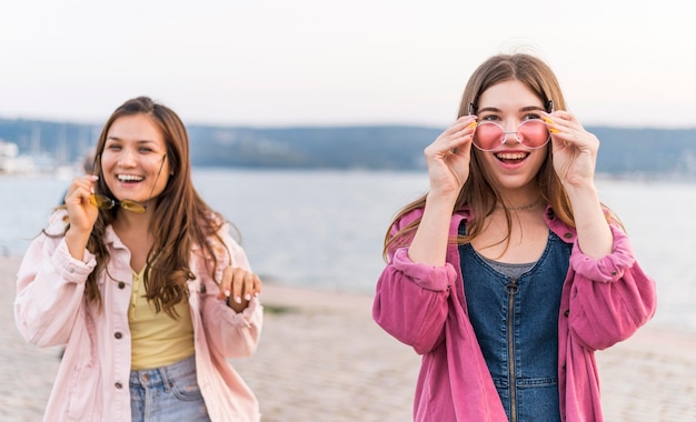 Amici femminili che hanno divertimento in riva al lago