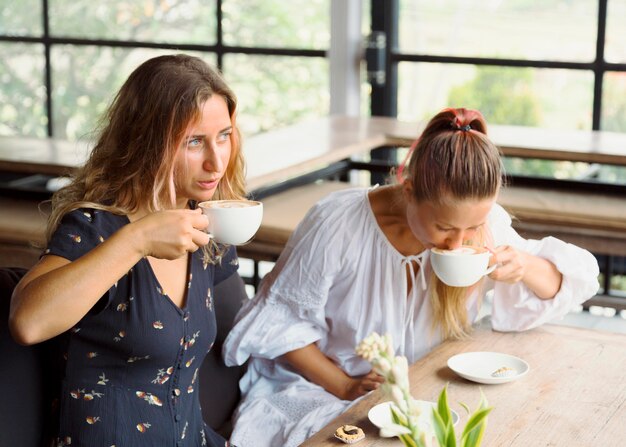 Amici femminili che mangiano caffè insieme