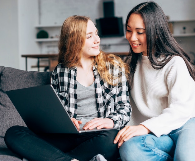 Amici femminili che per mezzo del computer portatile