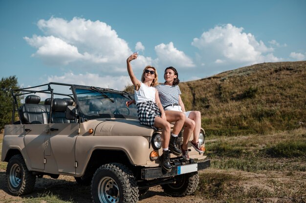 Amici femminili che prendono selfie mentre viaggiano in auto