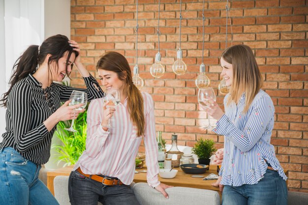 Amici femminili che ridono nella stanza dei mattoni