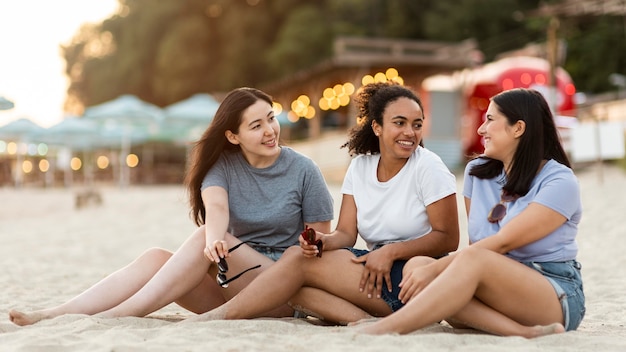 Amici femminili che si siedono sulla spiaggia