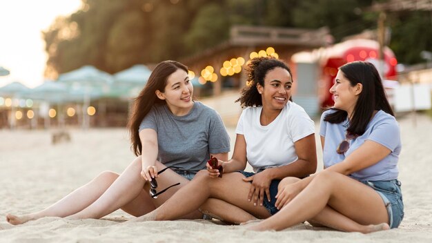 Amici femminili che si siedono sulla spiaggia