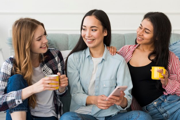 Amici femminili che spettegolano mentre bevendo caffè