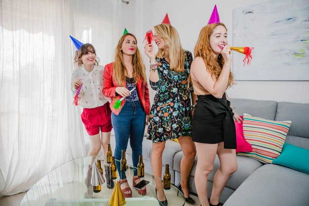 Amici femminili con corna e cappelli a festa