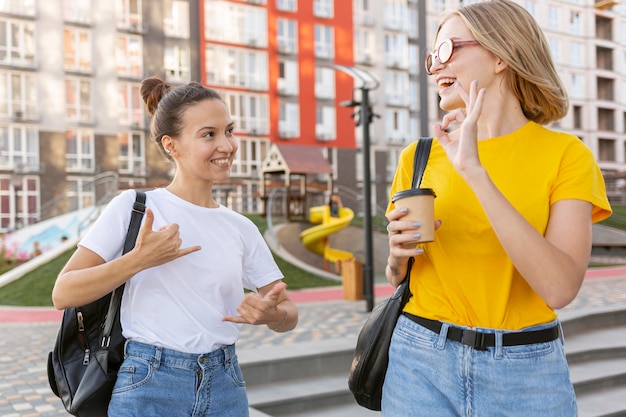 Amici femminili fuori usando il linguaggio dei segni