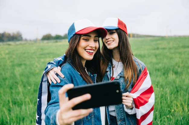 Amici femminili in posa sulla fotocamera del telefono