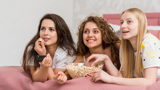 Amici in pigiama party a mangiare pop corn