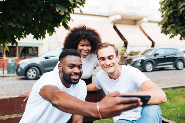 Amici interculturali nel parco prendendo selfie