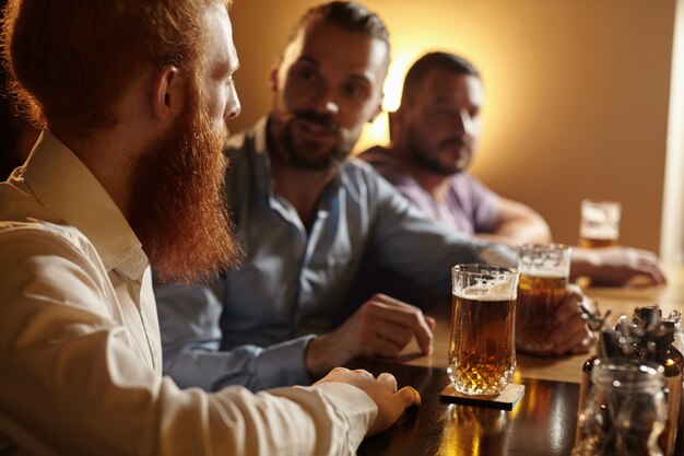 Amici maschi che bevono una birra al bar