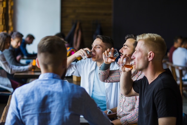 Amici maschii che godono delle bevande al bar