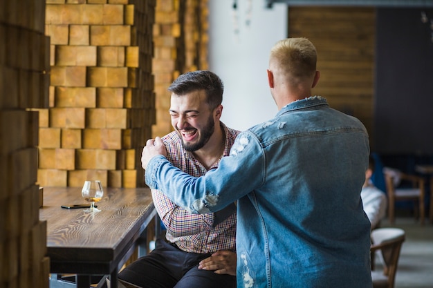 Amici maschii felici che si incontrano al ristorante