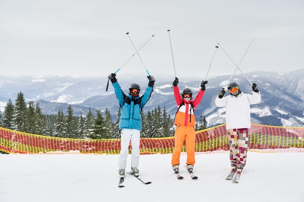 Amici sciatori che si divertono nella stazione sciistica in montagna in inverno con lo sci e lo snowboard