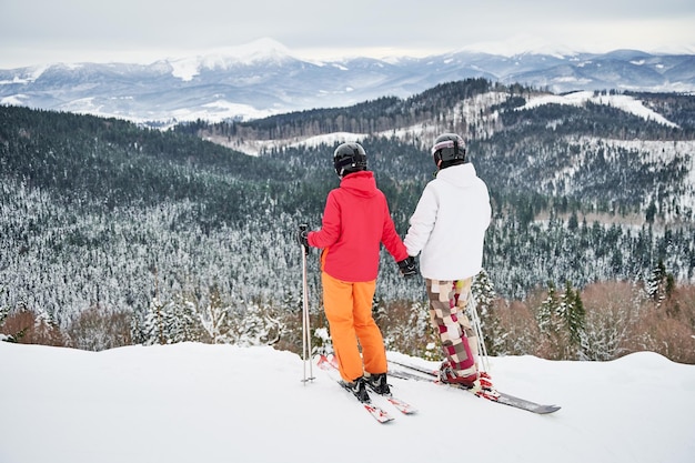 Amici sciatori che si divertono nella stazione sciistica in montagna in inverno con lo sci e lo snowboard