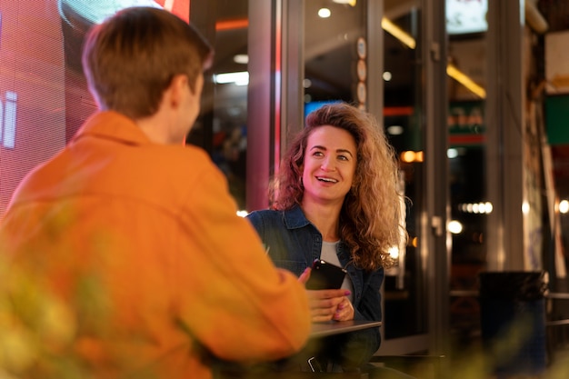 Amici seduti a un tavolo che parlano durante una serata fuori