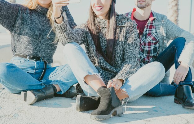 Amici seduti insieme e prendendo selfie