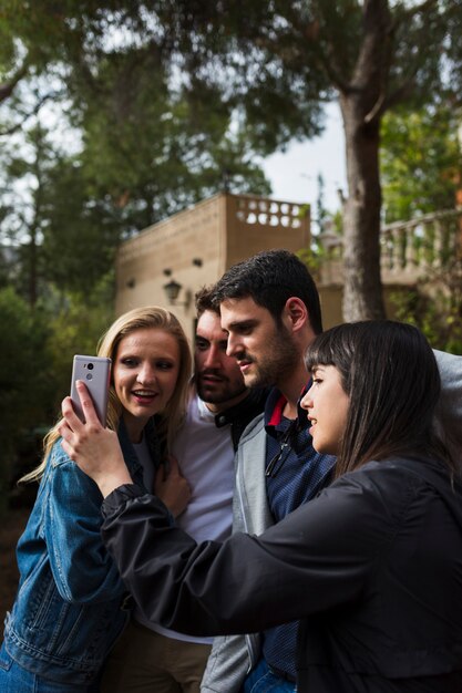 Amici sorridenti che prendono selfie in macchina fotografica mobile