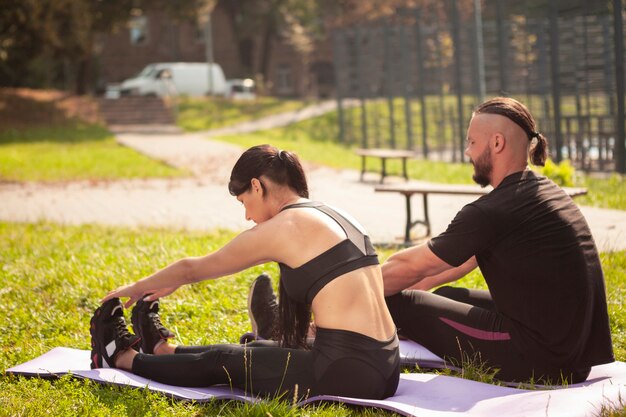 Amici sportivi sul tappetino allungando il corpo