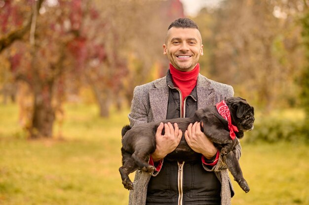 Amicizia. Un uomo sorridente felice con il suo cane nel parco