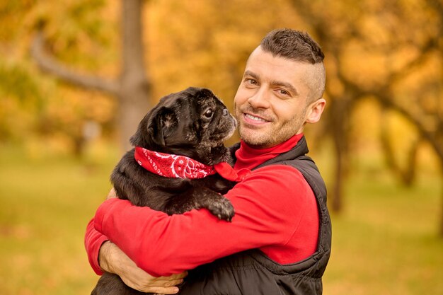 Amore. Un uomo in piedi nel parco e abbraccia il suo cane