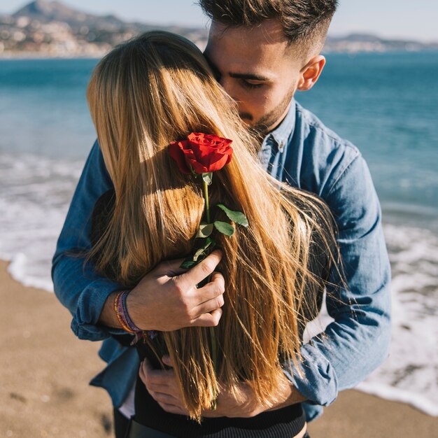 Amorevole abbraccio uomo e donna sulla spiaggia