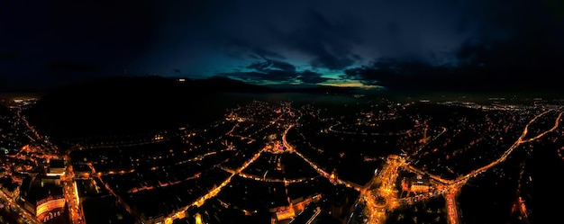 Ampia vista aerea del drone di Brasov di notte Romania Centro storico Luci notturne edifici strade