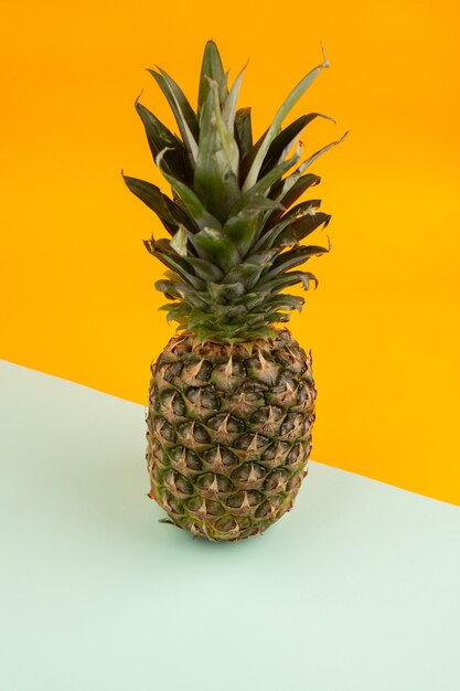 Ananas intero gustoso acido su un'acqua verde e arancione