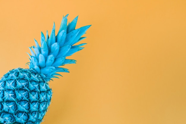 Ananas verniciato blu su sfondo giallo