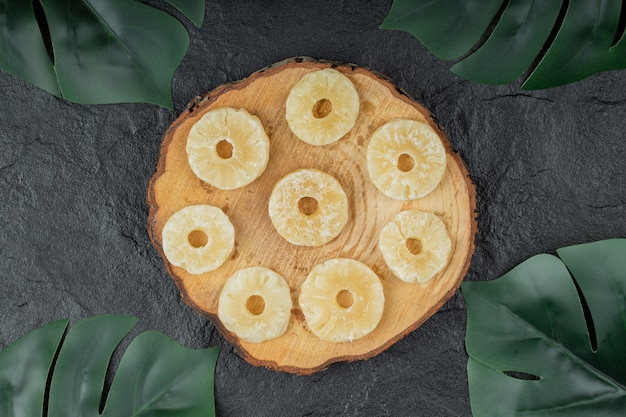 Anelli di ananas essiccati su pezzo di legno