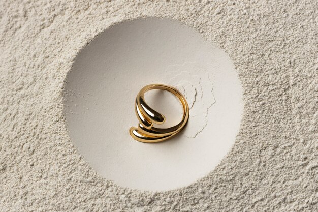Anello d'oro costoso con sfondo di polvere bianca