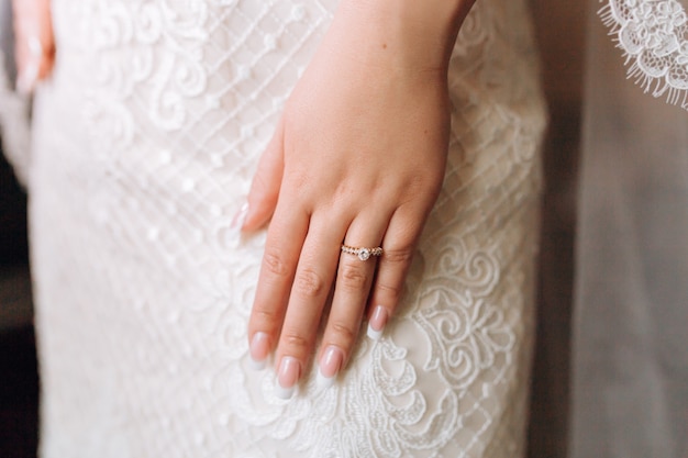 Anello di fidanzamento sulla mano della sposa con pietre preziose e bella manicure francese