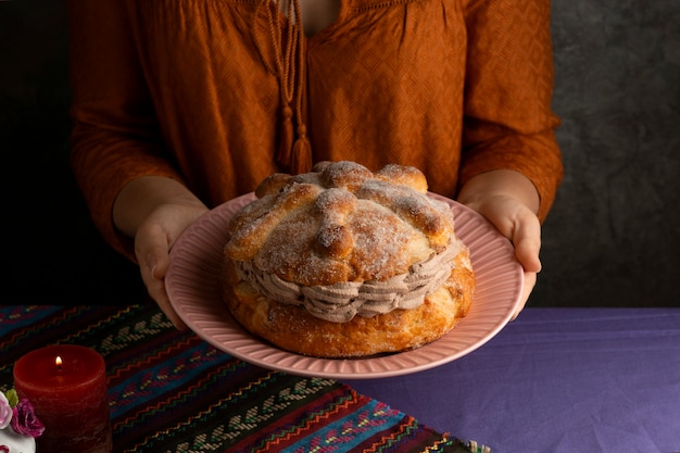 Angolo alto della donna che tiene il pan de muerte