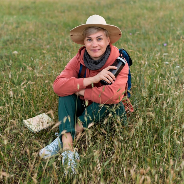 Angolo alto della donna turistica più anziana che posa in natura