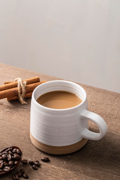 Angolo alto della tazza da caffè con bastoncini di cannella