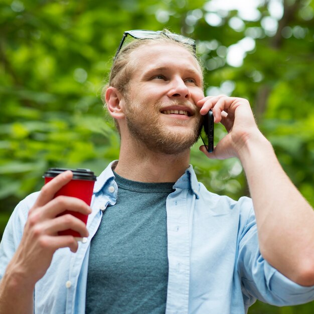 Angolo basso dell'uomo allegro che parla sul telefono