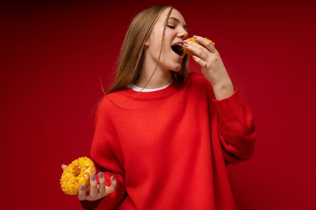 Angolo basso di una ragazza adolescente che mangia una ciambella