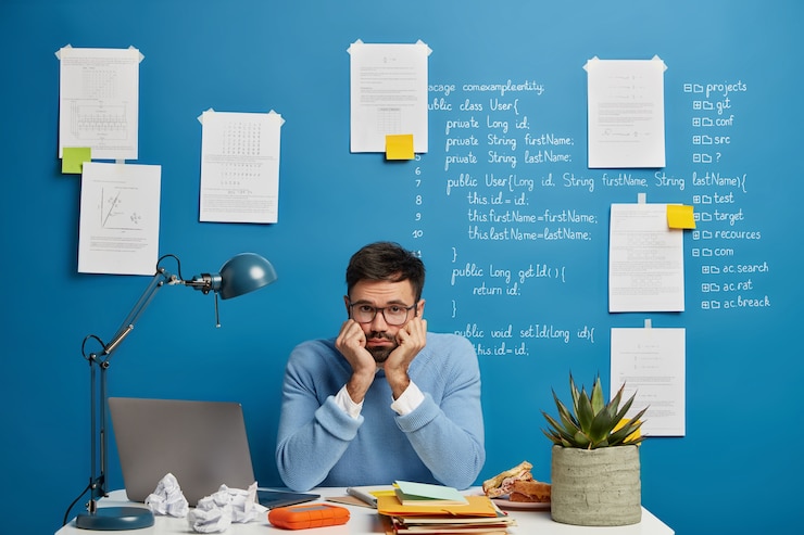 Foto gratuito annoiato maschio universitario ha fallito o problema durante il lavoro