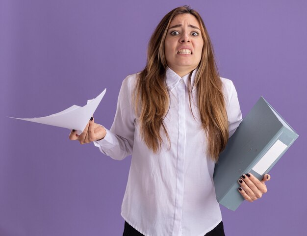 Ansiosa giovane bella ragazza caucasica che tiene fogli di carta e cartella di file